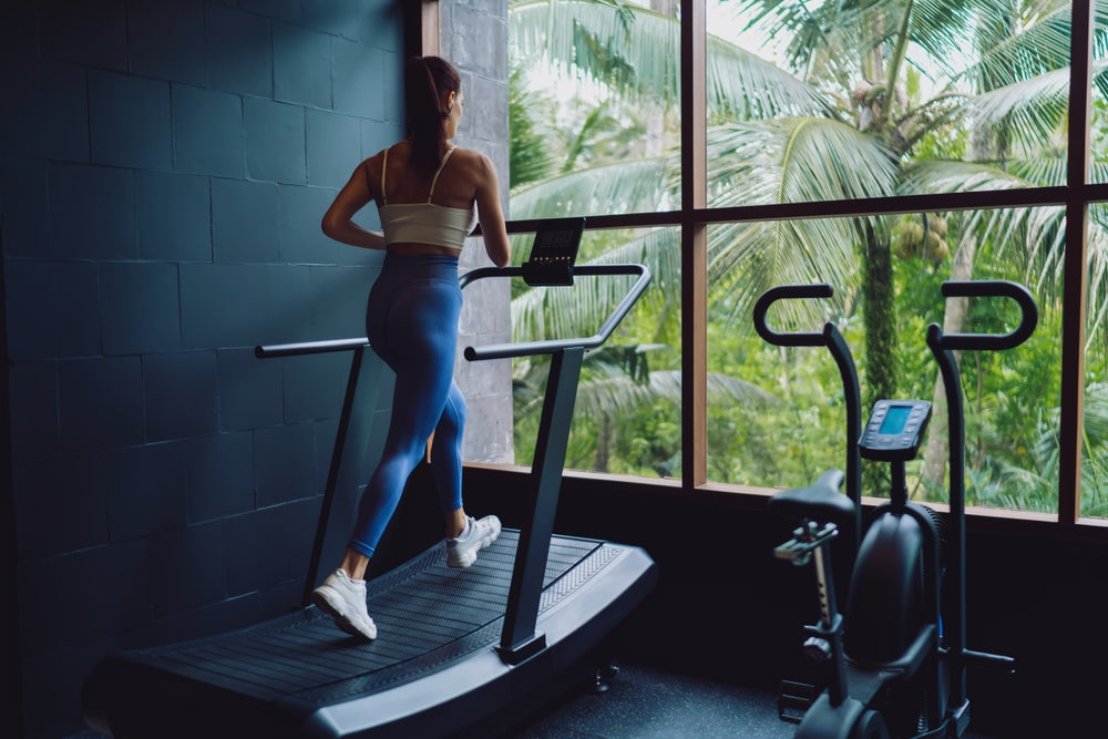 Frau trainiert auf curved Laufband im Fitnessstudio